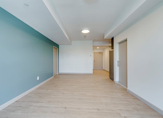 A long hallway with doors on both sides and a light on the ceiling.