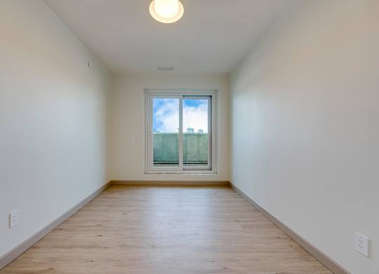 A room with a window and wooden floor.