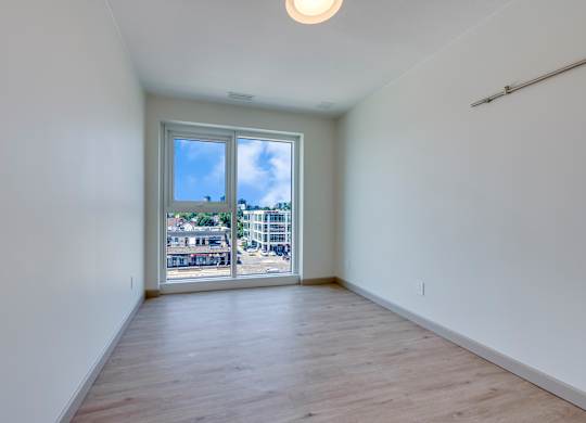 A room with a sliding glass door leading to a balcony.