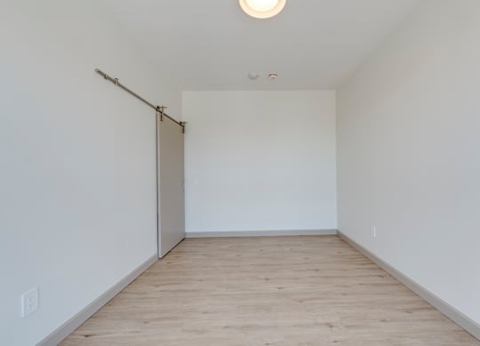 A room with a sliding door and wooden floor.