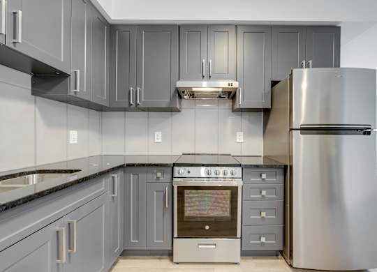 A modern kitchen with a stainless steel refrigerator and oven.