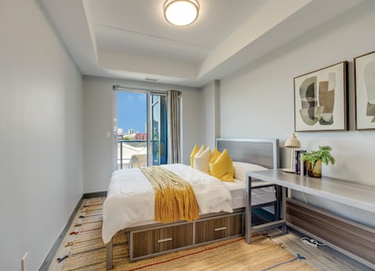 A bedroom with a bed, nightstand, and window.