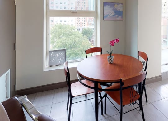 a dining room with a table and chairs and a window
