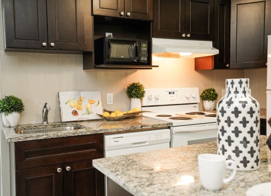 a kitchen with white appliances and granite counter tops