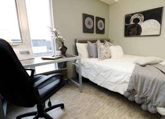 a bedroom with a bed and a desk with a chair