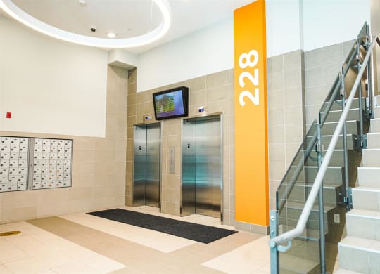 the lobby of a building with two elevators and a staircase