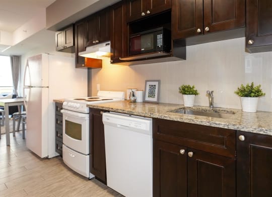a kitchen with white appliances and brown cabinets and a counter top