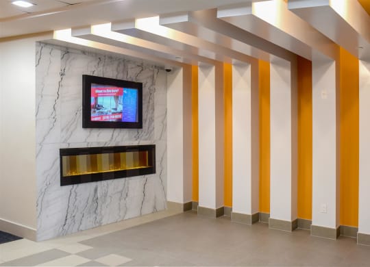the lobby of a building with yellow and white pillars and a television