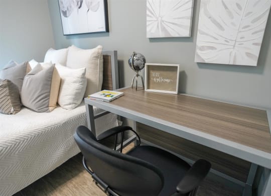 a desk with a chair in a room with a bed