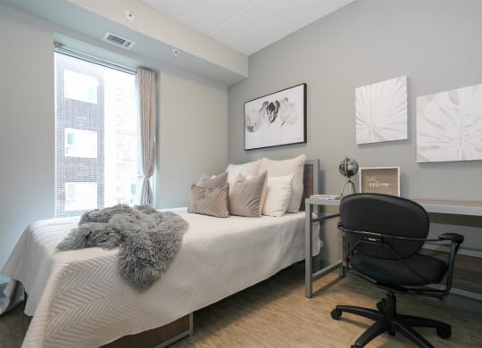 a bedroom with a bed and a desk with a chair