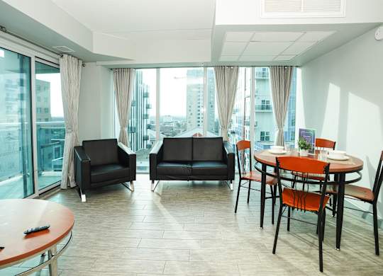 a living room and dining room with a table and chairs