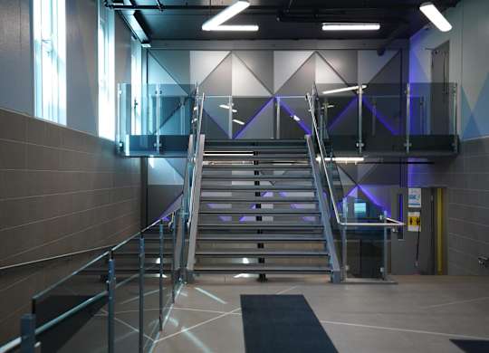 a set of stairs in a lobby with blue lights