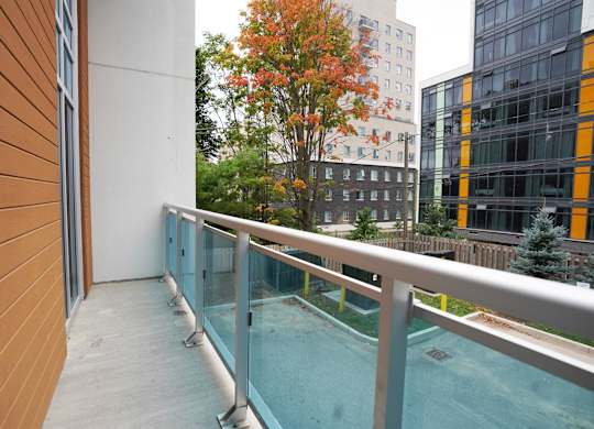 a balcony with a pool and a building in the background