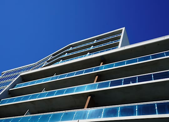 a tall building with blue windows against a blue sky