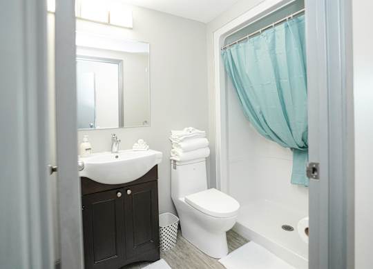 a bathroom with a toilet and a sink and a shower