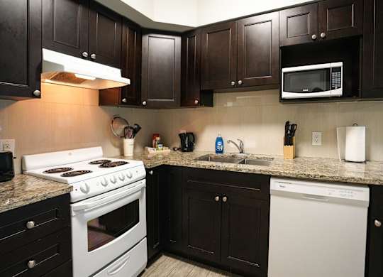 a kitchen with white appliances and granite counter tops