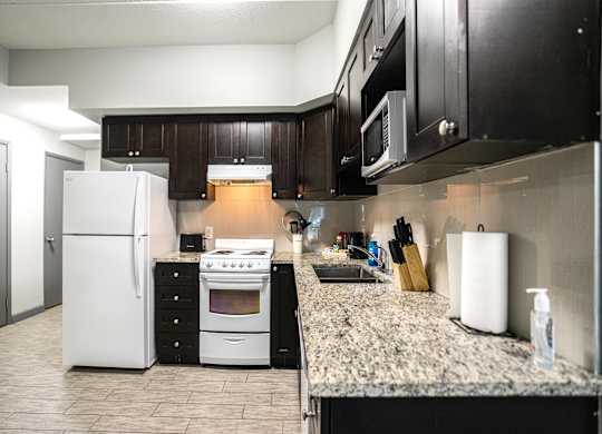 a kitchen with white appliances and a granite counter top