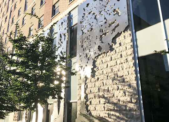 A building with a large window and a tree in front of it.
