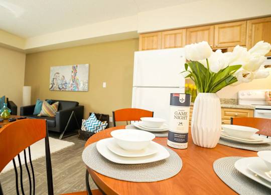 A dining room with a wooden table set for two.