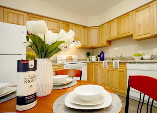 A kitchen with wooden cabinets and a table set for a meal.