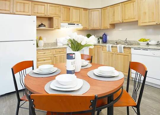 A kitchen with a table set for two.