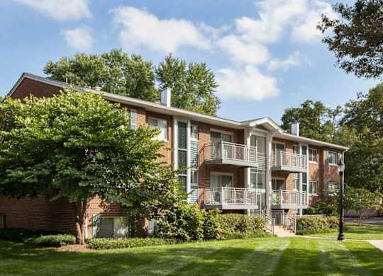 A large apartment building with a green lawn in front.