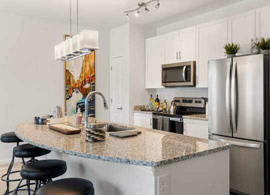 A kitchen with granite countertops and stainless steel appliances.
