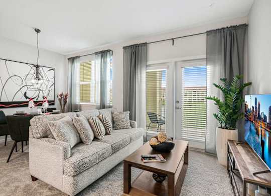 A living room with a grey couch, a coffee table, and a painting on the wall.