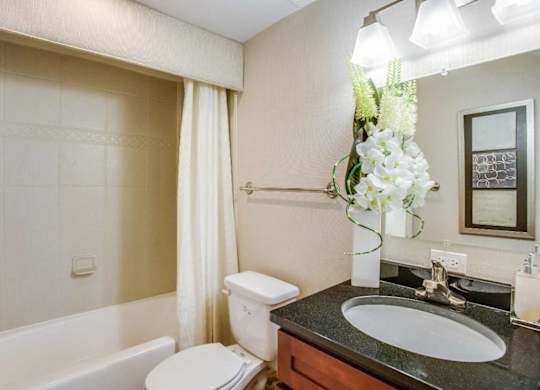 A bathroom with a white tub, toilet, and sink.