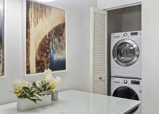 A modern laundry room with a washer and dryer stacked on top of each other.
