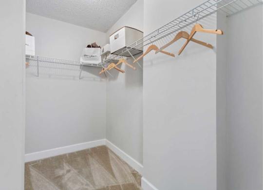 A white closet with a metal rack and wooden hangers.
