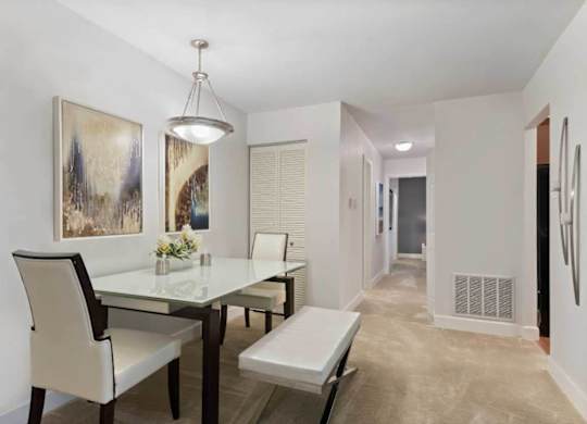 A dining room with a glass table and chairs.