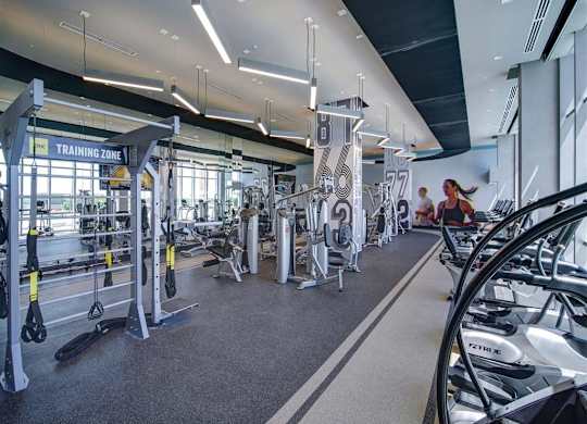 a gym with weights and other exercise equipment in the lobby of a building