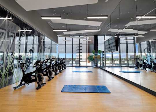 a gym with yoga mats and exercise machines on a wooden floor