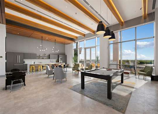 a large living room with a pool table  and a kitchen