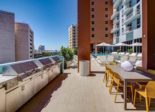 a rooftop terrace with tables and chairs and a pool