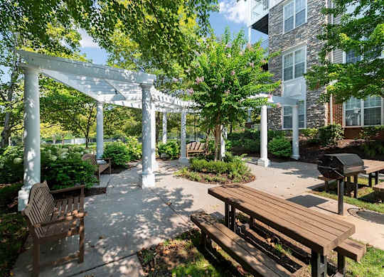 a courtyard with benches and a pergola