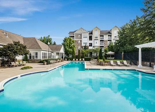 a large swimming pool with apartment buildings in the background