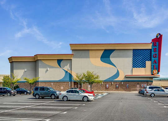 the facade of a building with cars parked in front of it