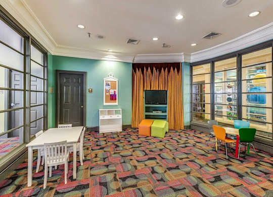 a living room with a table and chairs and a television