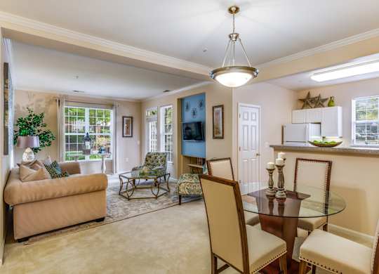 a living room and dining room with a table and chairs