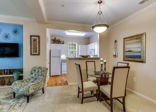 a living room and dining room with a table and chairs