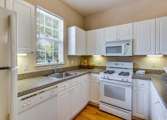 a kitchen with white appliances and white cabinets