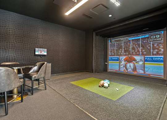 a room with a projector screen and a ball on the floor