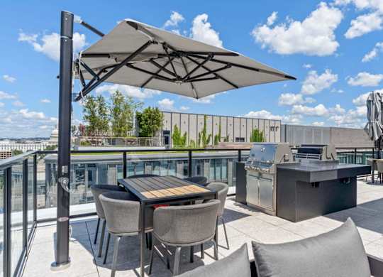 a rooftop patio with tables and chairs and a grill