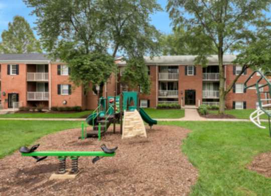 an aerial view of a playground in front of an apartment building