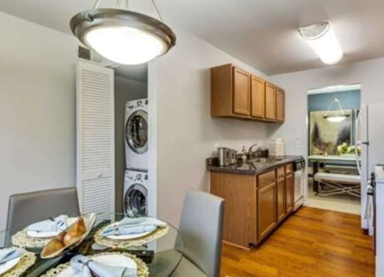 a dining room table and a kitchen with a washing machine