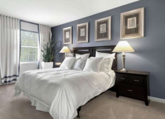 a bedroom with a bed and a carpet with colored dots
