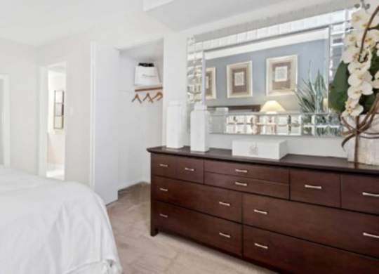 a bedroom with a bed and a dresser and a mirror