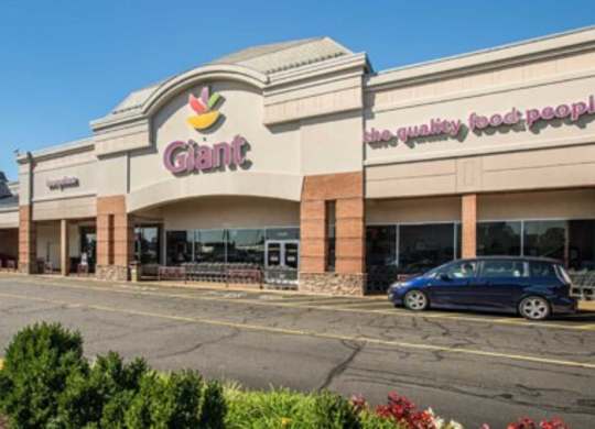 the exterior of a shopping center with a car parked outside